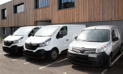 A fleet of small vans parked outside a commercial unit