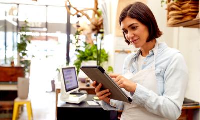 A small business entrepreneur checks her social media stats on a tablet device