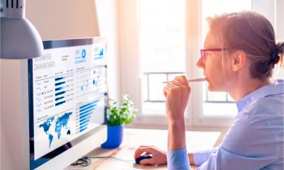 A businesswoman looks at business analytics on the computer screen