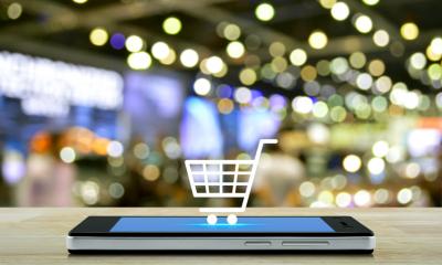 Mobile phone with a shopping trolley graphic popping out on top of screen