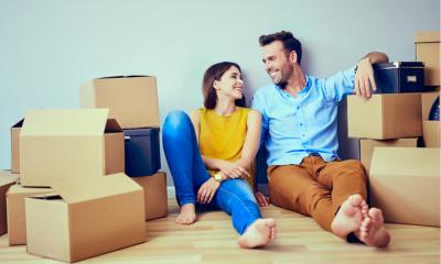 Happy couple having break during moving at their new house