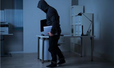 Man taking laptops from an office during the night
