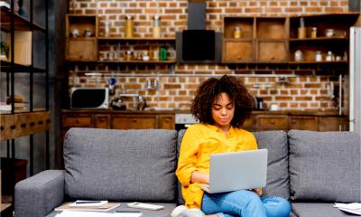 A woman works from home on her personal laptop