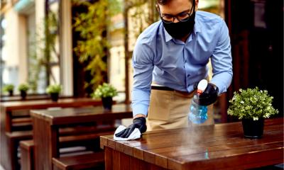 A waiter cleans a table in a COVID-secure manner