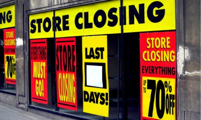 Store closing signs in a high street shop window