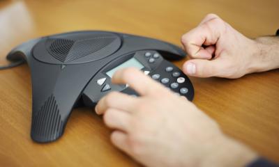 Conferencing systems An office worker dials in to a conference call using conferencing equipment