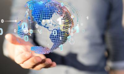 A male hand holding a digital composite of the world