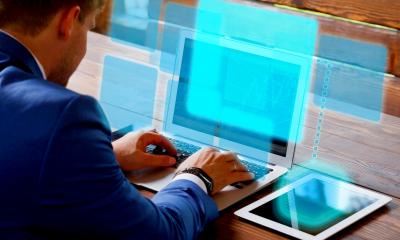 Man in a blue suit using his laptop to create a virtual office