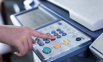 An employee changes the settings on the office printer to reduce the printing costs