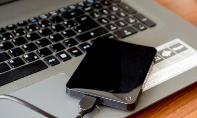 Black USB drive plugged into a laptop backing up data