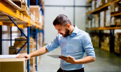 An attractive man checks his warehouse stock inventory