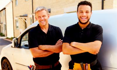 Portrait of a young and a middle-aged tradesman by their van