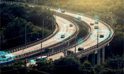 GPS-tracked vehicles move through the traffic on a busy city road.