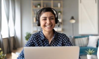 Happy worker in front of their laptop working from home