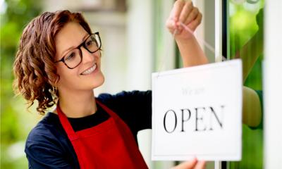 A smiling woman re-opens her cafe after the lockdown
