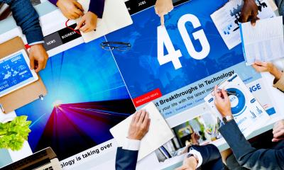 Table filled with superfast mobile internet posters with peoples hands holding various objects