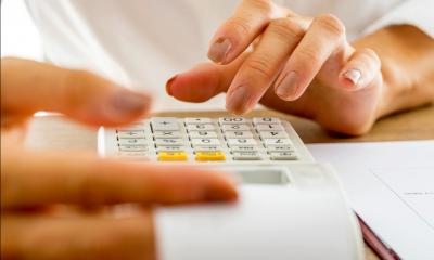 A woman is using a calculator to work out the cost per page of her printer