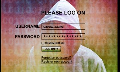 Black writing with login details in front on someone with their hood up