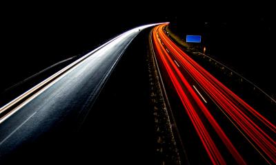 A motorway taken in the dark showing front and back car lights in a blur