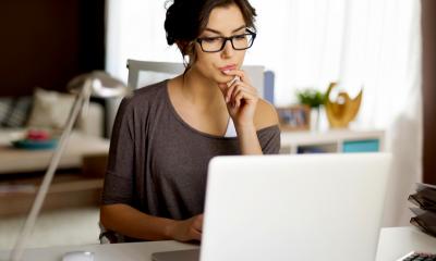 Introducing home working - checklist Woman with brown hair and glasses with laptop working from home
