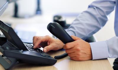 Dialing on a landline telephone to contact an IT support company
