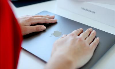 A woman places her hands on her macOS device to protect it