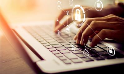 Hands typing on a keyboard with padlock icons - configuring IT security settings concept.