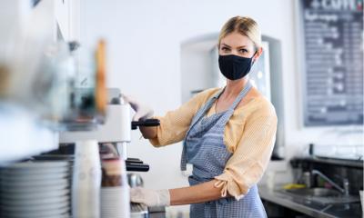 Coffee shop woman owner working with face mask, open after lockdown quarantine
