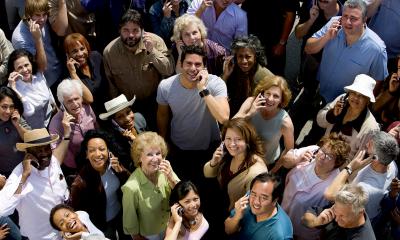 Multiple people looking up at the camera who are all on their mobile devices