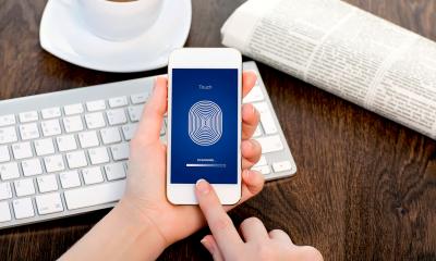 Person scanning their finger using mobile security software on their phone