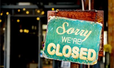 A closed sign in a shop window forced to close by local coronavirus restrictions