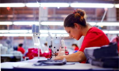 A young seamstress is working in a clothing factory