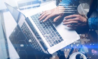 A man works at a laptop in a sunny office, seen from above - cyber security concept.