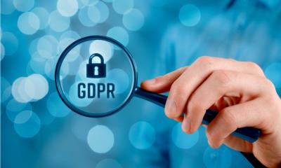 A person holds a magnifying glass up to GDPR compliance
