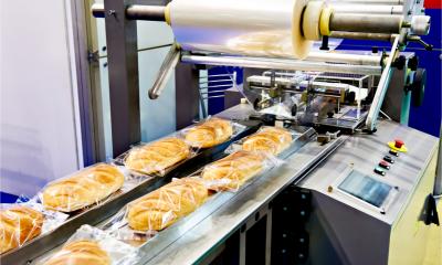 Packing machine with a roll of film for loaves of bread