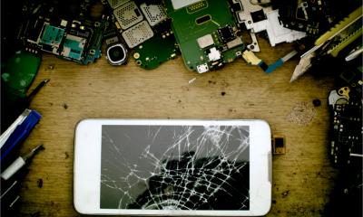 View from above of a broken smart phone and various components