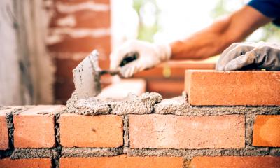 A builder building a wall of bricks