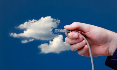 Blue sky with clouds and a hand holding an ethernet cable up to the cloud