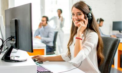 An employee sits at her desk using her computer accessories