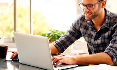 A copywriter edits his article on his laptop