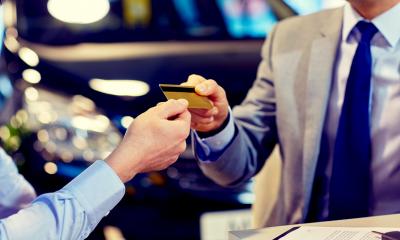 Purchasing IT - checklist Person passing their credit card to another checkout worker.