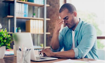 Stressed freelancer sits in front of laptop and worries about meeting his deadline