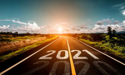 A road heading towards the sunrise with 2021 written on it