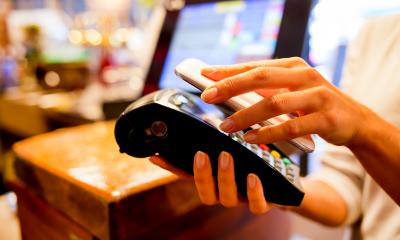 Woman using her phone to make a mobile payment in a shop