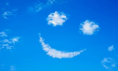 Smiling face formed from clouds in a blue sky