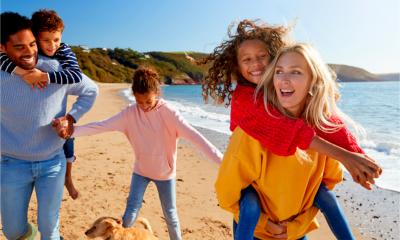 Two parents on a beach with their children