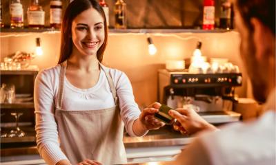 A female barista takes a card payment from a customer