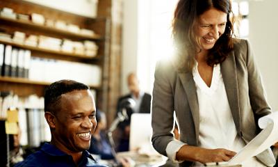 Using consultants - checklist Business woman shows information on a piece of paper to smiling business man