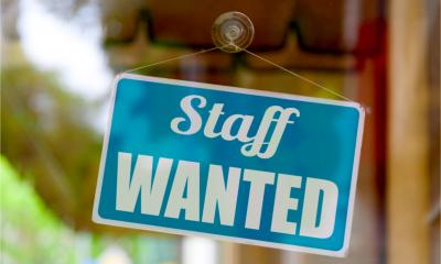A sign saying Staff wanted in a shop window