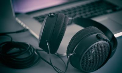 Website audio and video A pair of headphones on a desk next to a laptop